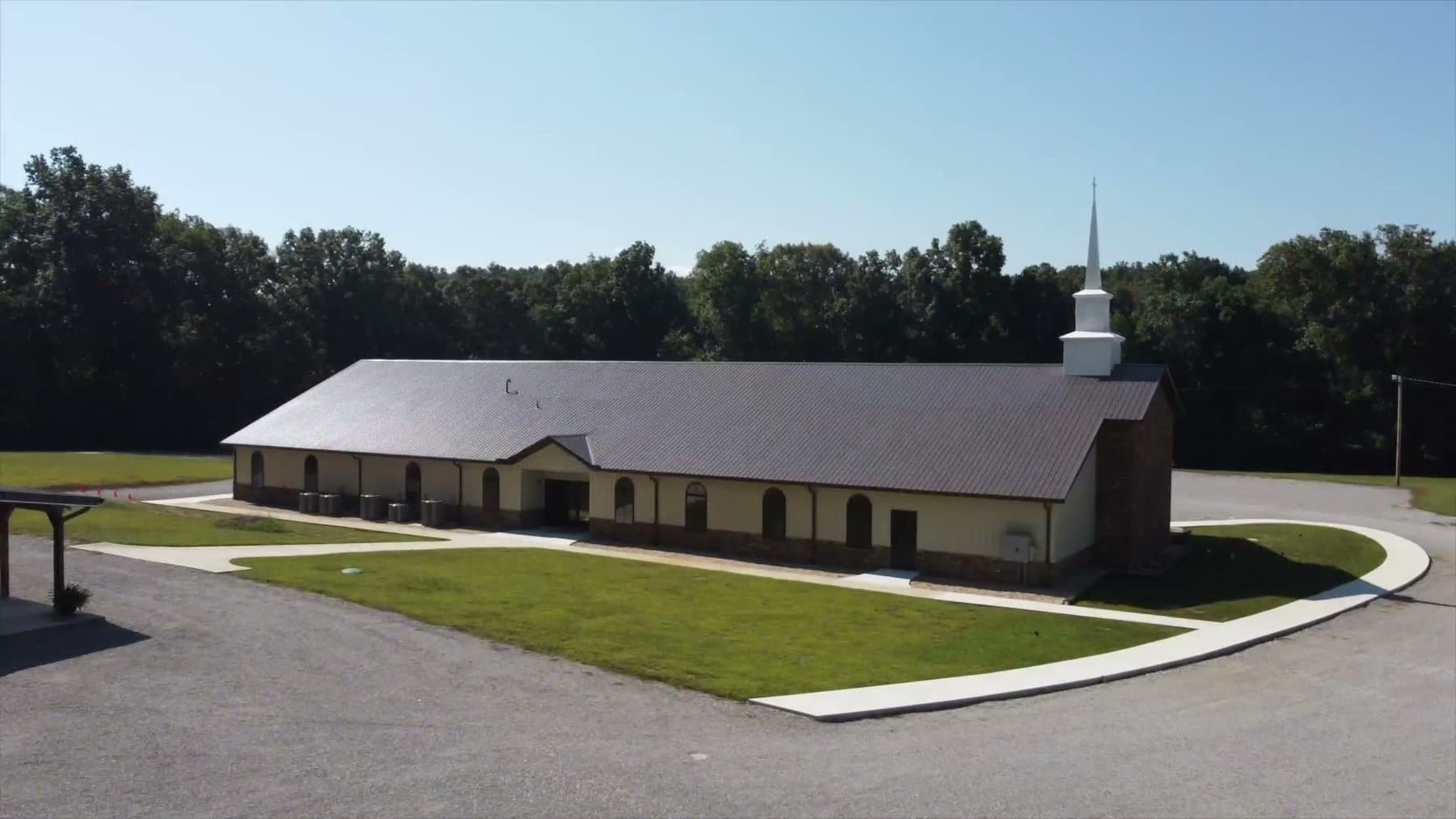 The new church building from the air, with the paved drive, the workshop, and the Tabernacle behind it
