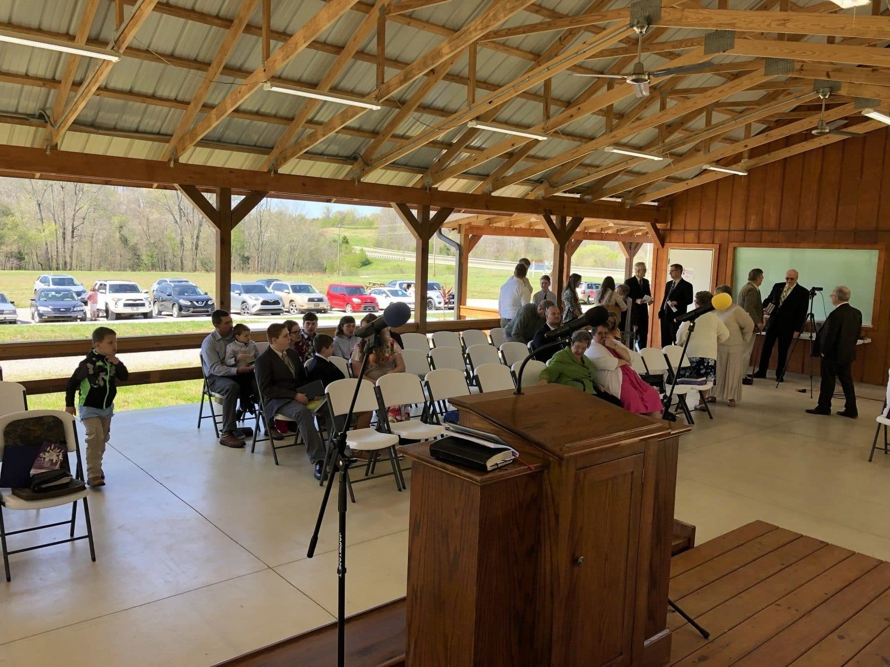 Folding chairs set out under the timber-framed pavilion for an open-air service