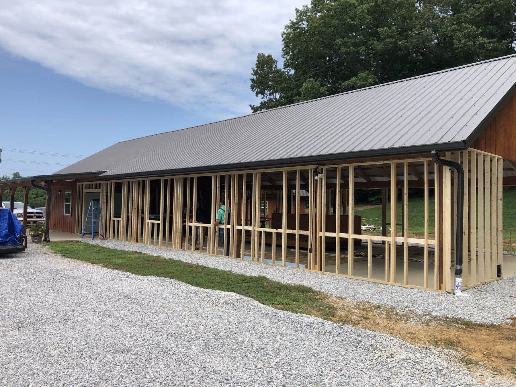 The pavilion mid-renovation, newly framed stud walls open to the weather under the finished roof